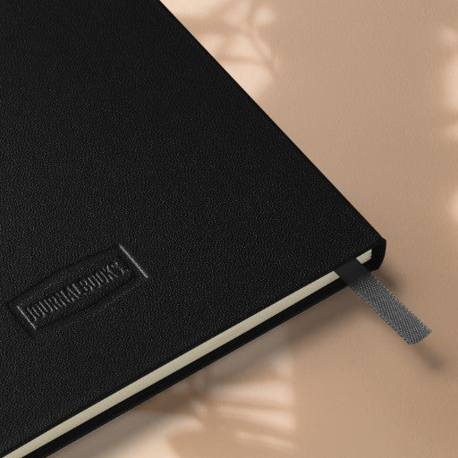 Hardcover Notizbuch goldene Lotusblüte mit schwarzem Einband in Rückseiten-Detailansicht mit sichtbarer Struktur, Leseband und cremefarbenen Seiten