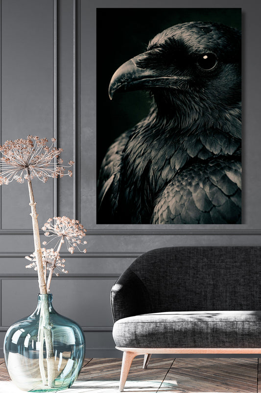 Poster eines schwarzen Raben in Nahaufnahme an grauer Wand über einem dunklegrauen Sofa neben einer großen Bodenvase aus Glas mit großer Blüte