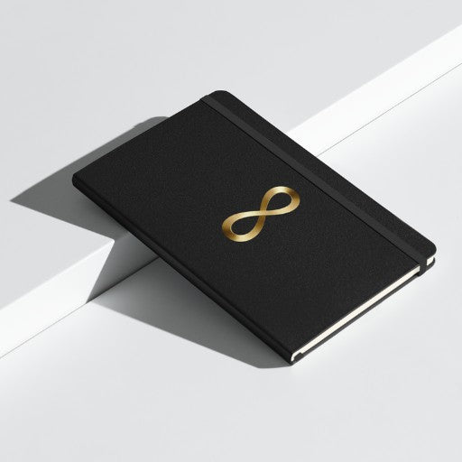 Hardcover Notizbuch mit Unendlichkeitszeichen in Goldoptik auf schwarzem Einband, Vorderseite als Produktmockup aufr weißem Podest