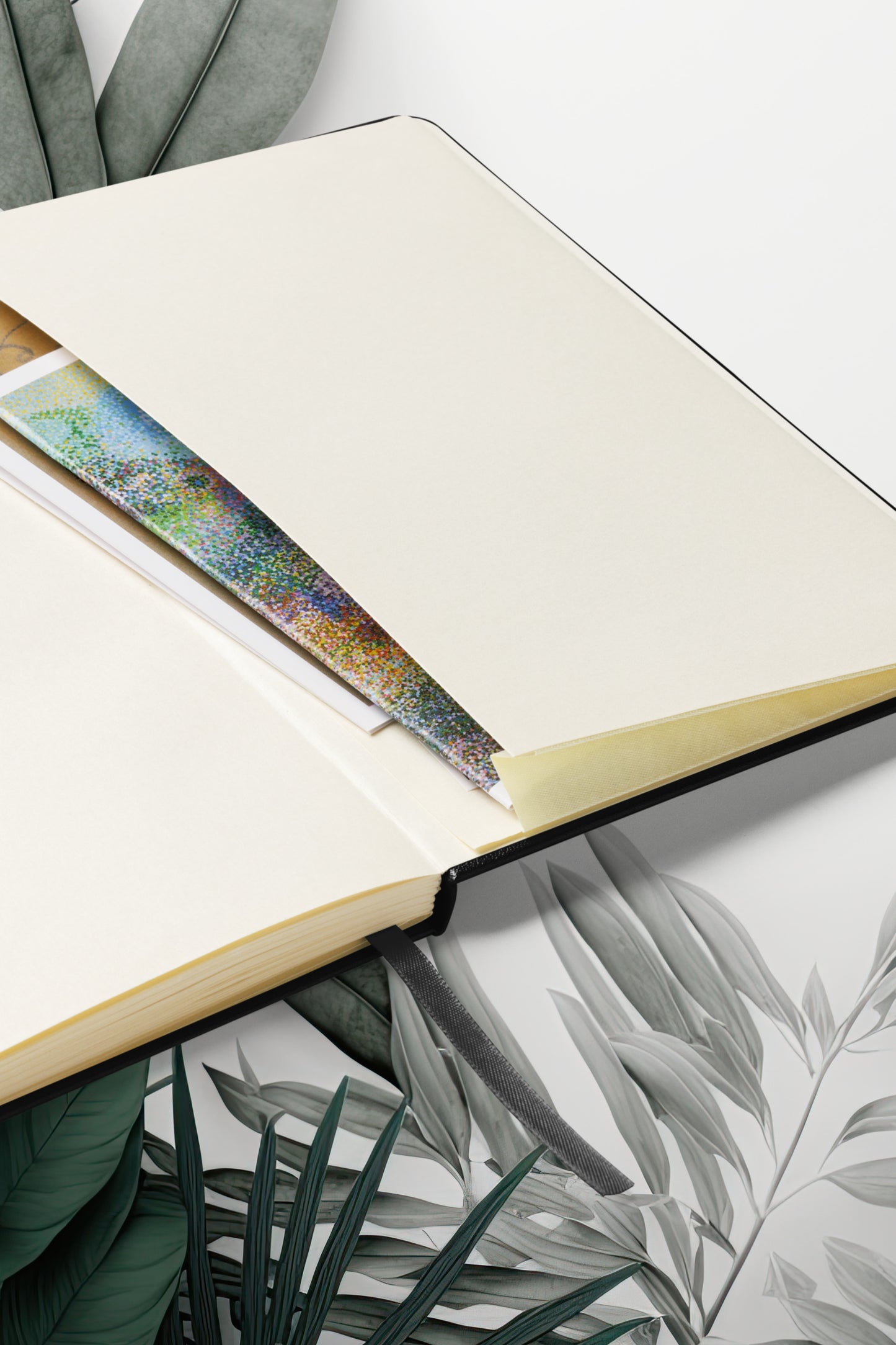 Hardcover Notizbuch Om Symbol mit geöffneten cremefarbenen Seiten und integriertem Leseband in Nahaufnahme.