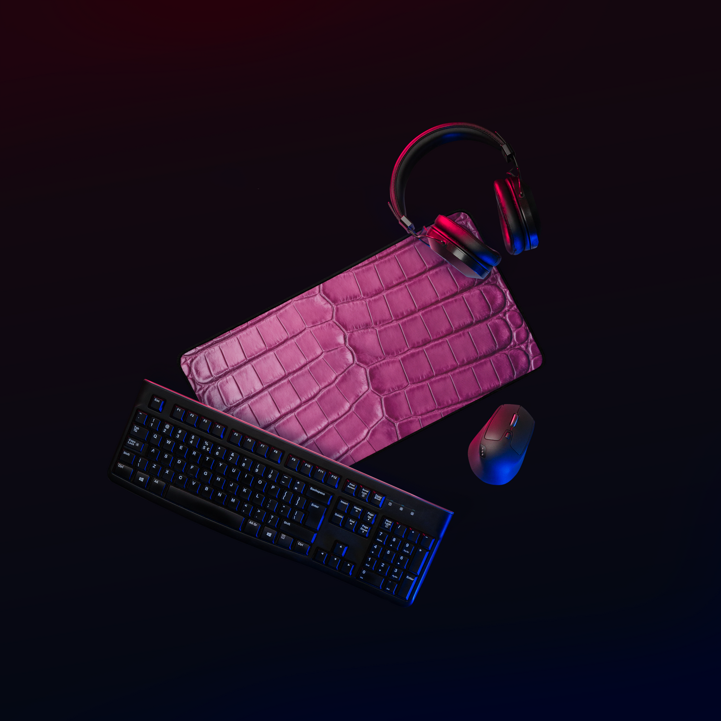Magentafarbene Schreibtischunterlage in Krokoleder Optik mit Kopfhörern, Tastatur und Maus in dunklem Workspace mit moderner Beleuchtung.