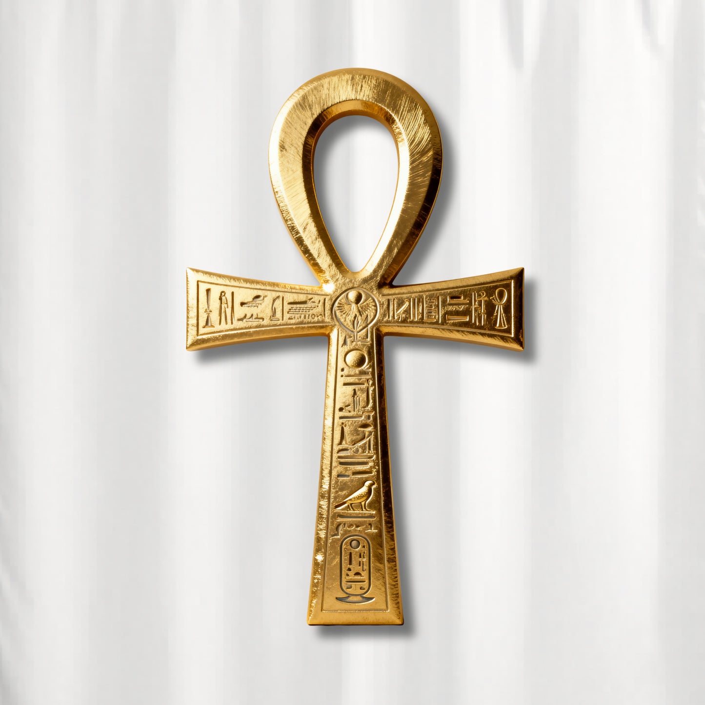 Detailaufnahme des goldenen Ankh-Symbols mit eingravierten Hieroglyphen auf weißem Duschvorhang mit luxuriöser Metalloptik und feinen Strukturdetails.