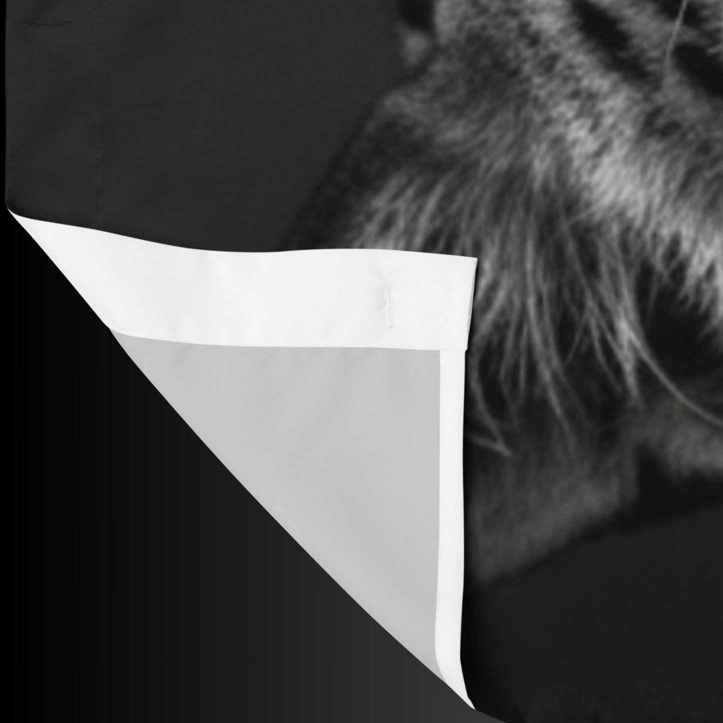 Detailansicht des schwarzen Duschvorhangs mit Jaguar-Motiv und sichtbar umgeschlagener Stoffkante zur Darstellung von Material und Verarbeitung