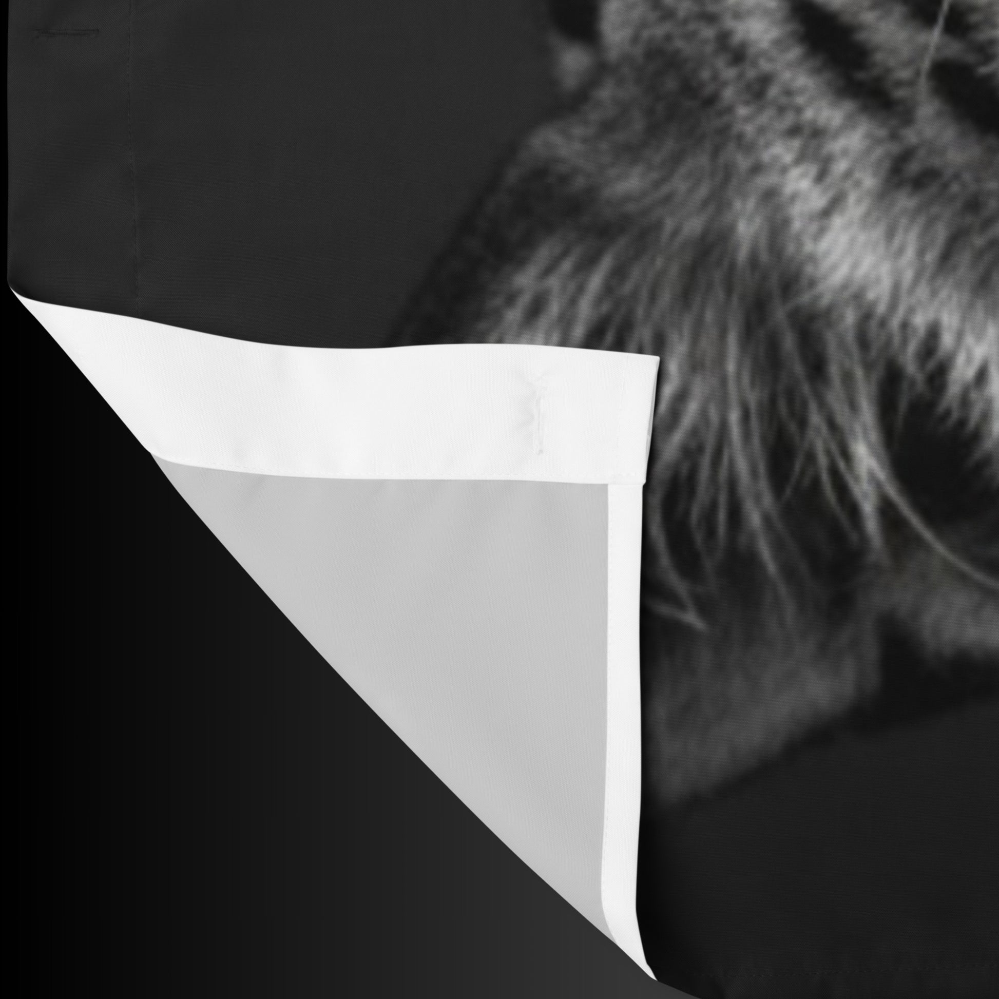 Detailansicht des schwarzen Duschvorhangs mit Jaguar-Motiv und sichtbar umgeschlagener Stoffkante zur Darstellung von Material und Verarbeitung