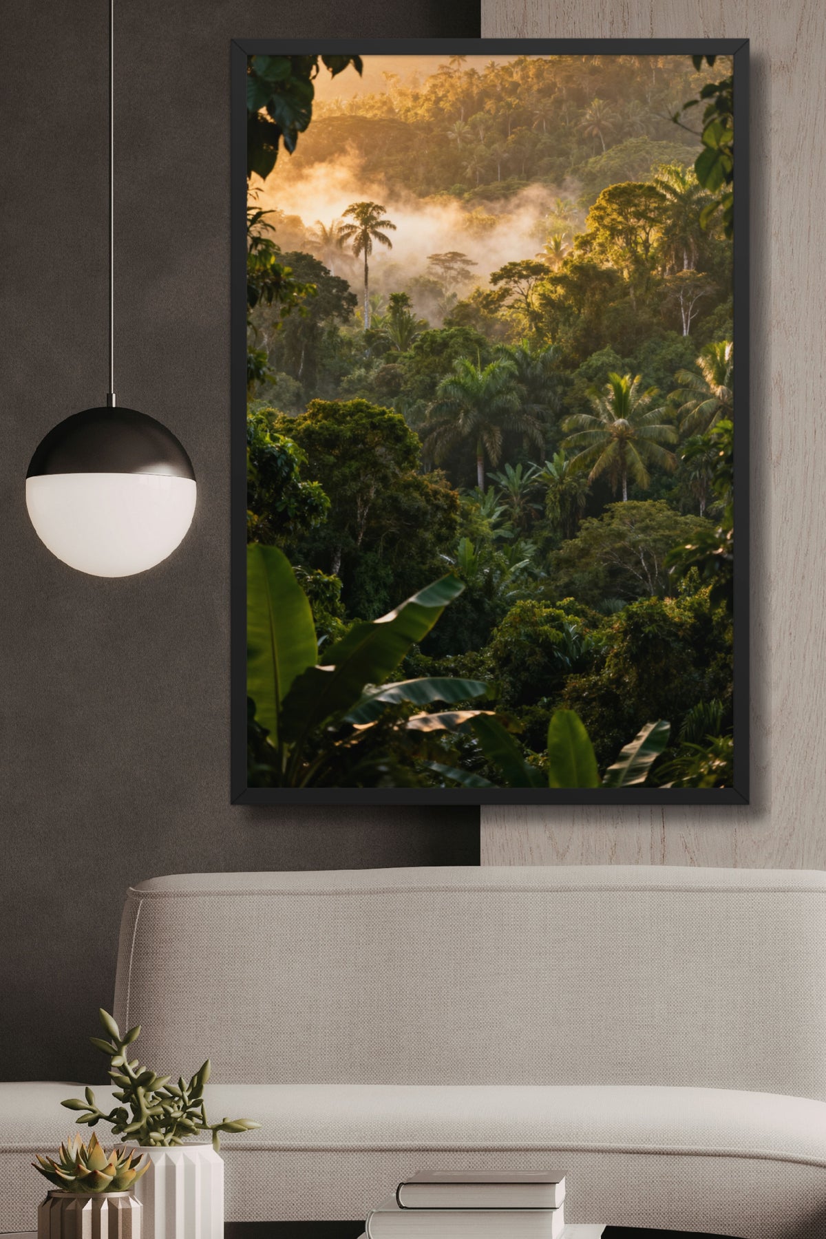Gerahmtes Poster mit tropischem Regenwald und Nebel an einer dunklegrau-weissen Wand über einem hellen Rattansofa neben einer eleganten Hängeleuchte