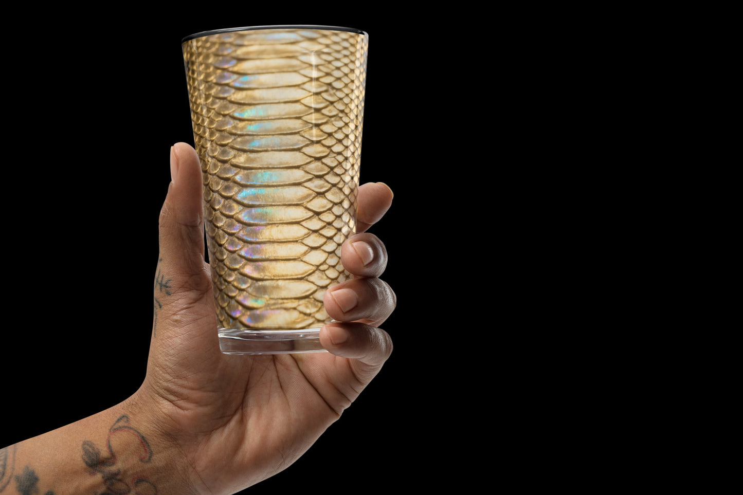 Gold-schwarzes Strukturglas mit glänzender Reptilienoptik frontal in der Hand gehalten