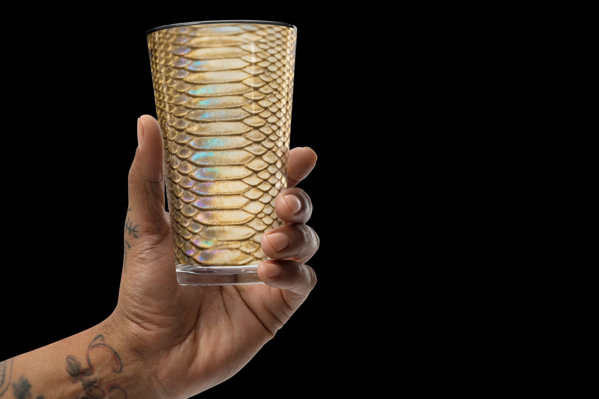 Gold-schwarzes Strukturglas mit glänzender Reptilienoptik frontal in der Hand gehalten