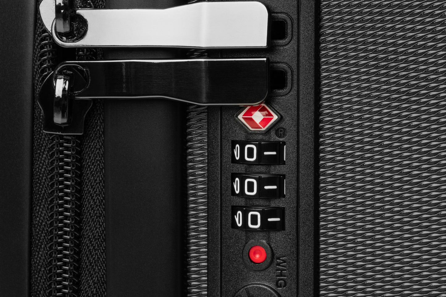 Detailaufnahme des integrierten TSA-Zahlenschlosses am Hartschalenkoffer. Die Nahansicht zeigt das sichere Verschlusssystem, die robuste Verarbeitung und die hochwertige Ausstattung für geschütztes Reisegepäck auf nationalen und internationalen Reisen.