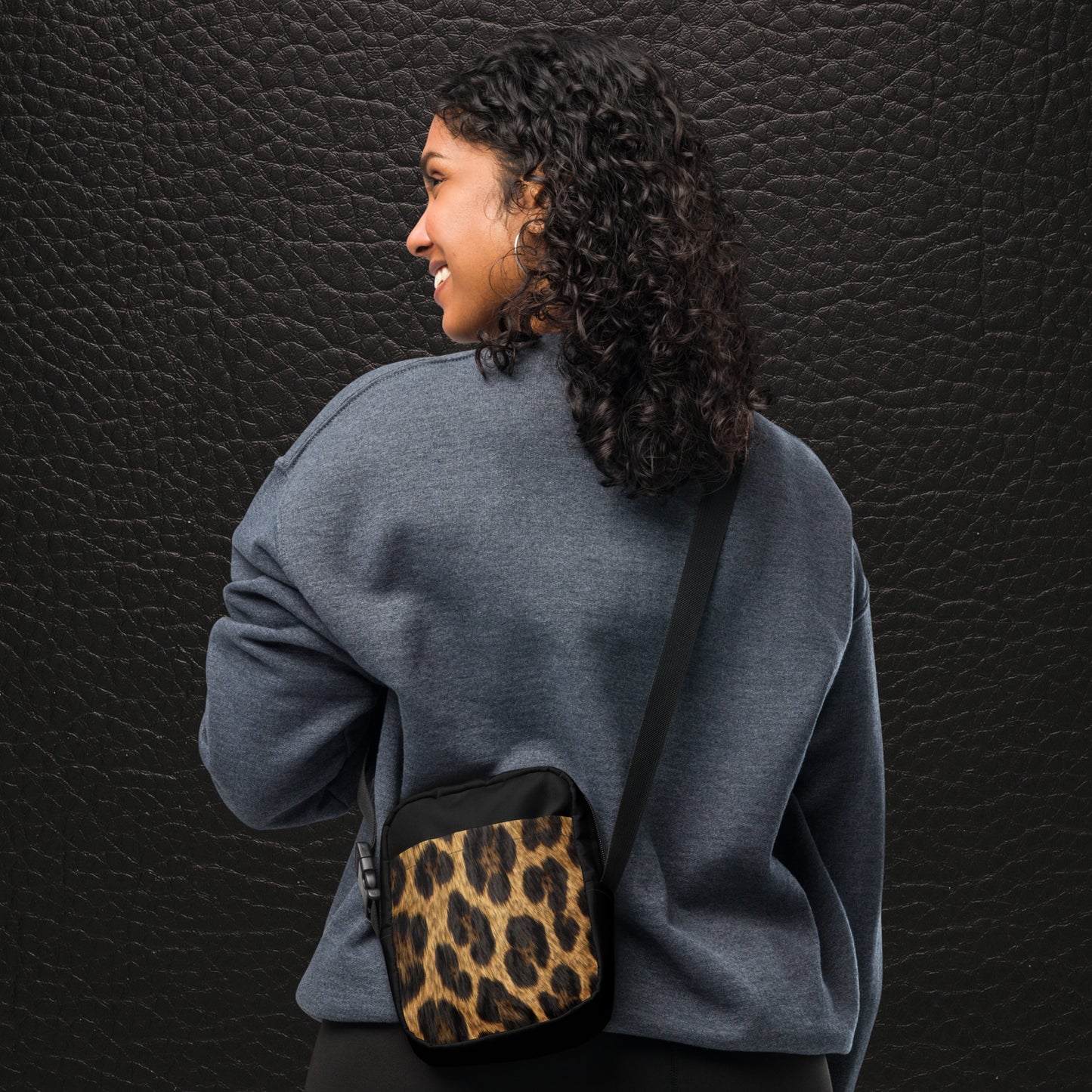 Crossbody Bag mit Jaguarfell-Print an der Vorderseite, getragen von hinten von Frau, verstellbarer Schultergurt, schwarze Seiten