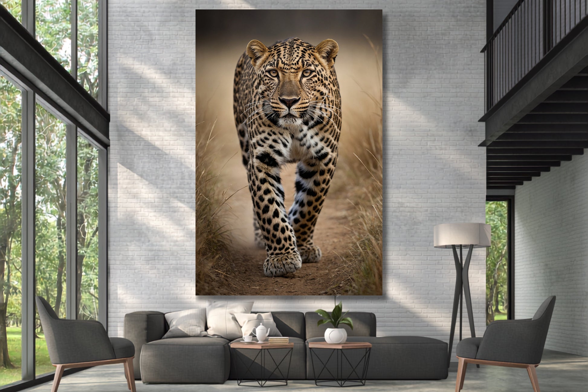 Leinwand eines Leoparden in frontaler Ausrichtung an einer hohen weißen Mauer über einer großen grauen Wohnlandschaft in einer Galerie mit großen Fenstern