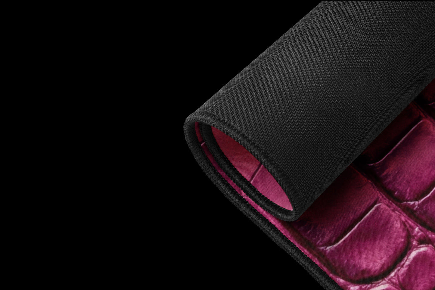 Gerollte magentafarbene Desk Mat mit schwarzer Unterseite und strukturierter Krokoleder-Optik