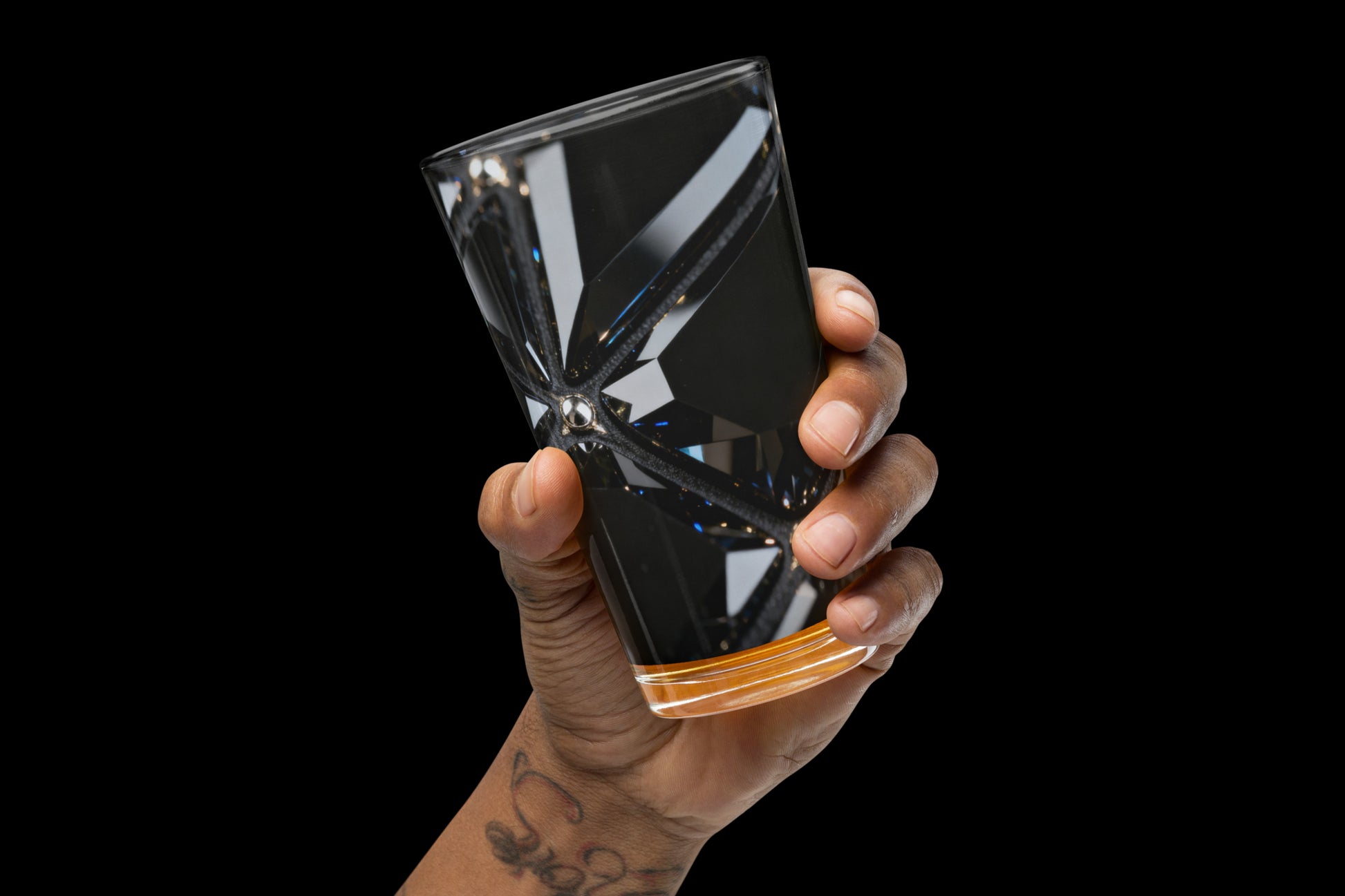 Schwarzes Obsidian Glas mit facettierter Kristallstruktur in der Hand gehalten