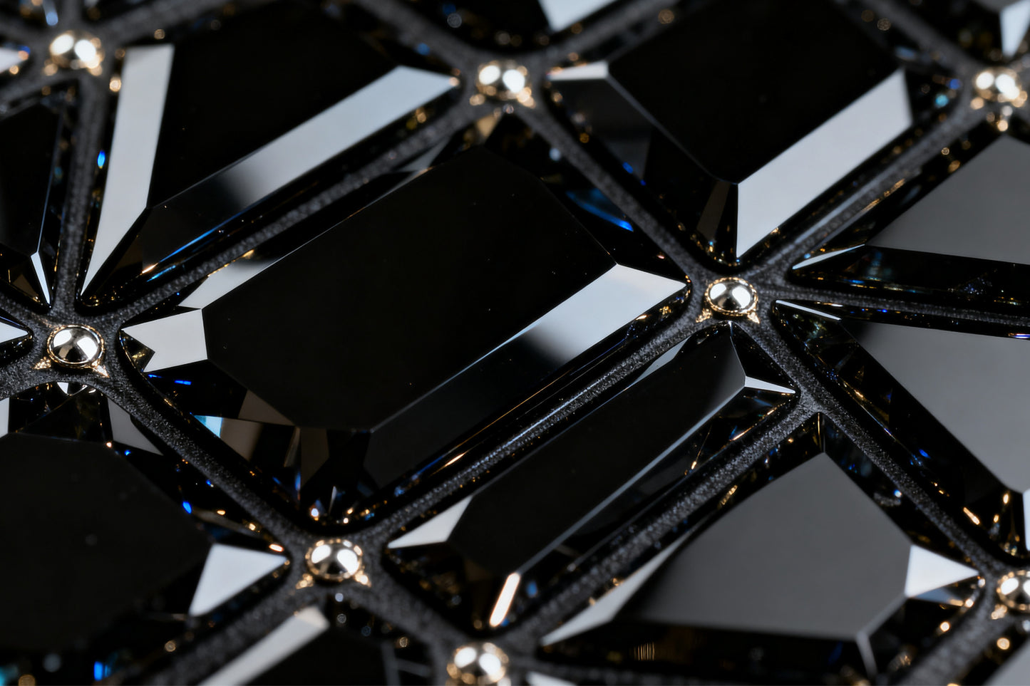 Detailaufnahme der facettierten Kristallstruktur eines schwarzen Obsidian Glases mit glänzenden Reflexen