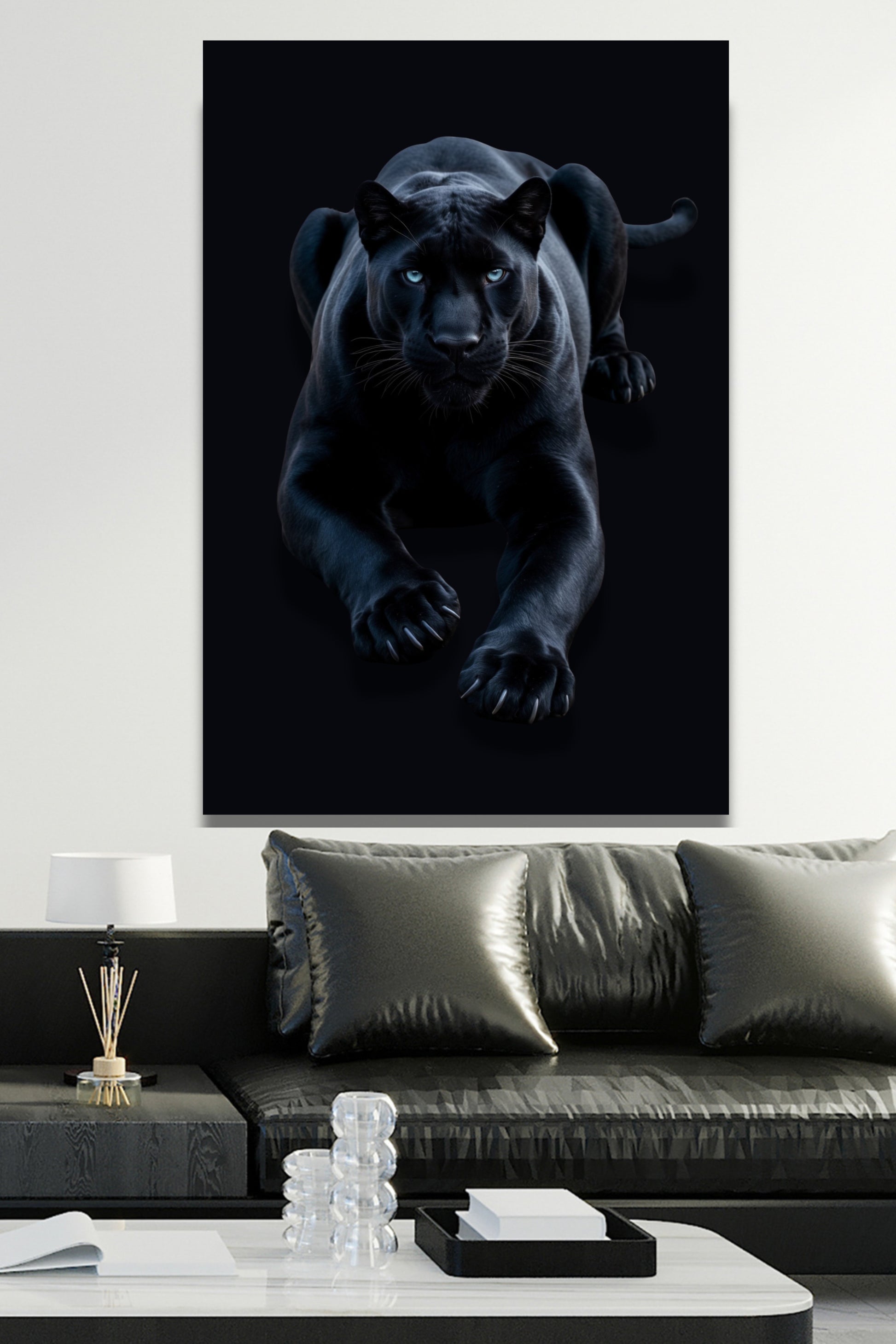 Poster eines schwarzen Panthers an weisser Wand über einem schwarzen Sofa mit Kissen und weissem Couchtisch