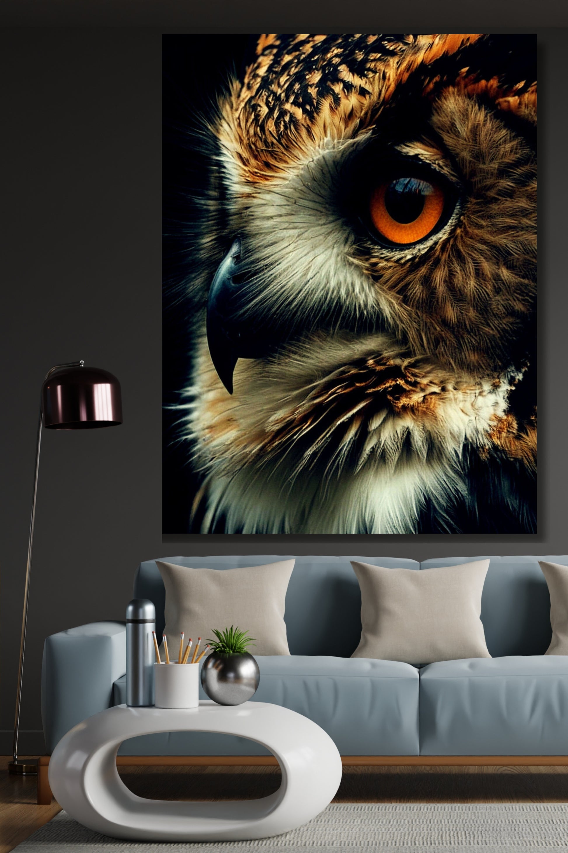 Poster einer Eule im Close up an einer dunklen Wand über einem hellblauen Sofa neben einer silbernen Stehleuchte
