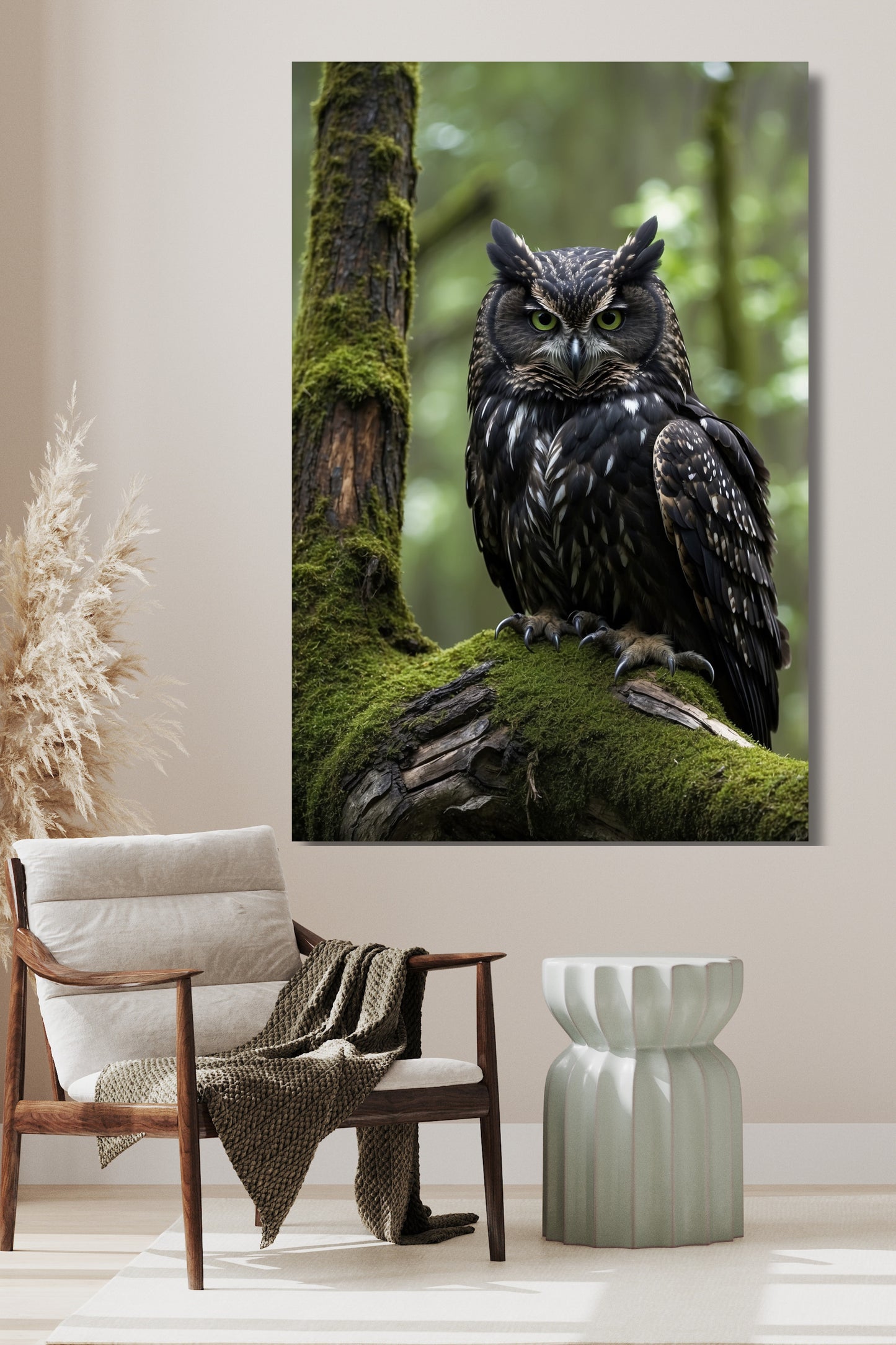 Poster Eule im moosigen Wald als Wandkunst über einem Holzsessel mit hellem Kissen, grünem Beistelltisch und dekorativen Trockenpflanzen vor heller Wand.