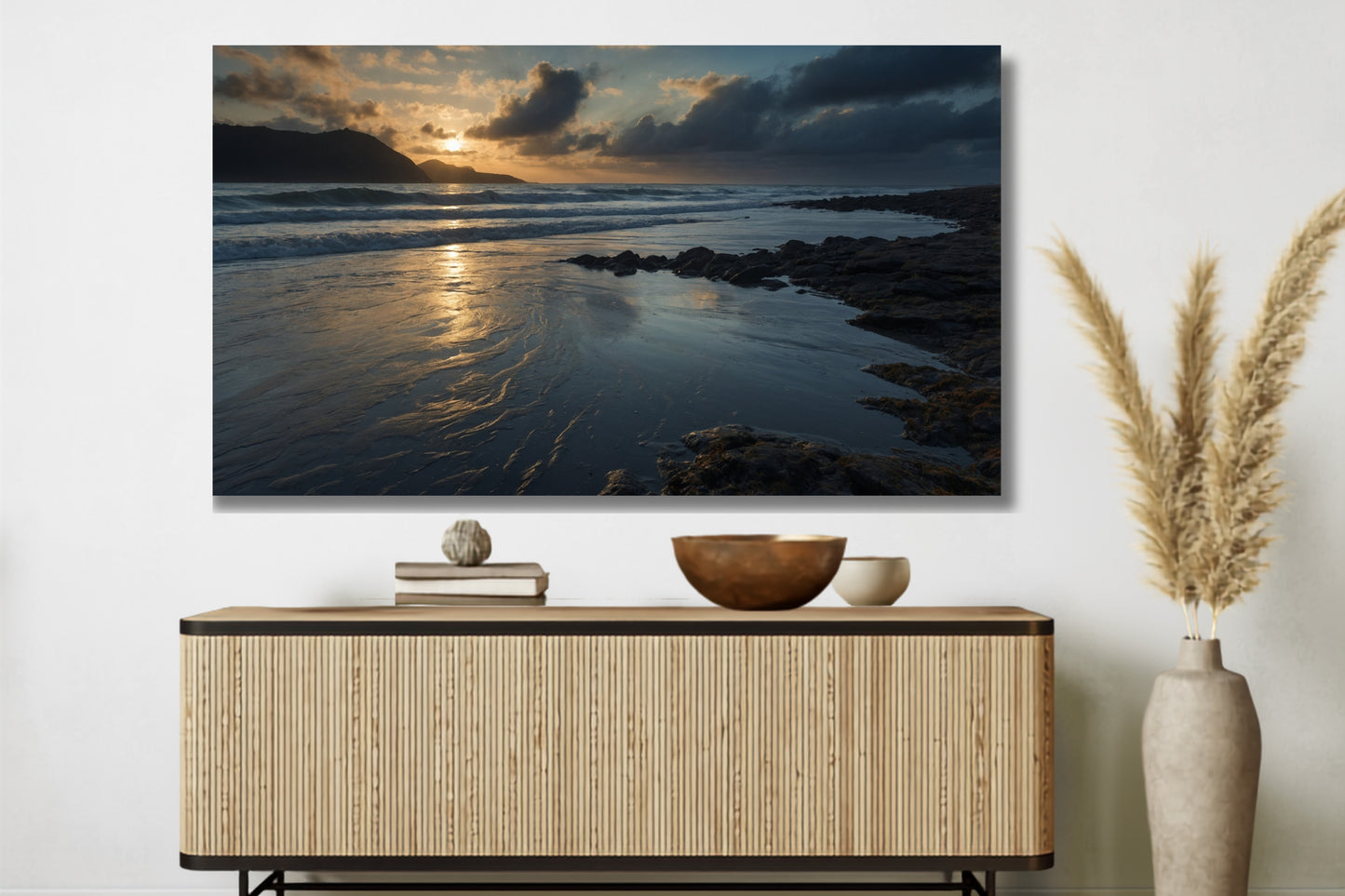 Poster einer Meereslandschaft in der Dämmerung über einem Sideboard in einem modernen Wohnraum mit dekorativer Vase und Pampasgras.