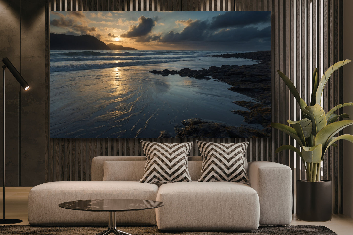 Poster einer Meereslandschaft in der Dämmerung über einem hellen Sofa in einem modernen Wohnzimmer mit Holzlamellenwand, Stehleuchte und großer Zimmerpflanze.