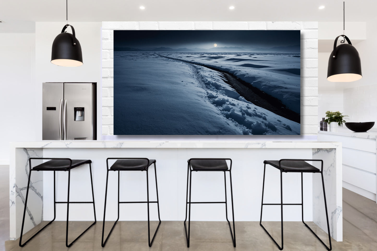 Poster einer Schneelandschaft im sanften Mondlicht über einer modernen Kücheninsel in einer hellen Küche mit schwarzen Pendelleuchten und Barhockern.