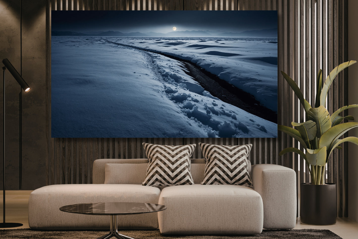 Poster einer Schneelandschaft im sanften Mondlicht über einem hellen Sofa in einem modernen Wohnzimmer mit Holzlamellenwand, Stehleuchte und großer Zimmerpflanze.