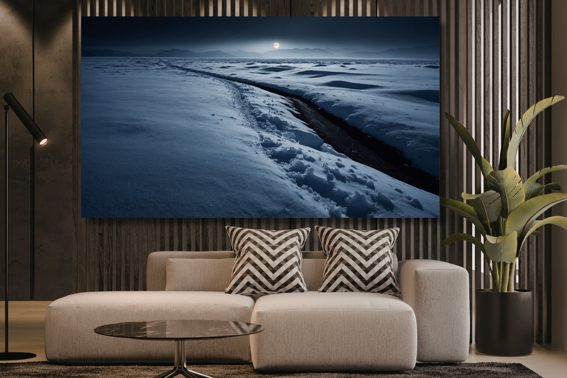 Poster einer Schneelandschaft im sanften Mondlicht über einem hellen Sofa in einem modernen Wohnzimmer mit Holzlamellenwand, Stehleuchte und großer Zimmerpflanze.