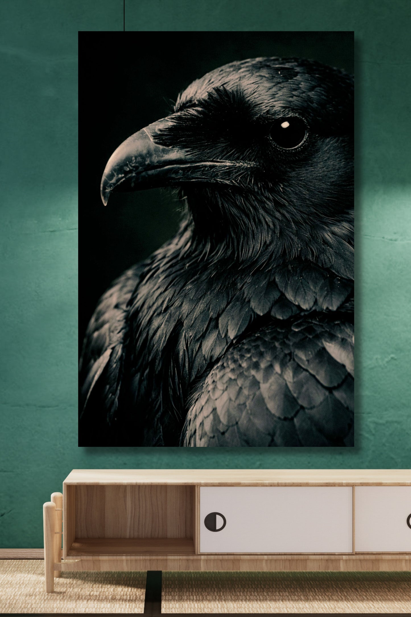 Poster eines schwarzen Raben in Nahaufnahme an einer türkisfarbenen Wand über einem Sideboard aus Holz