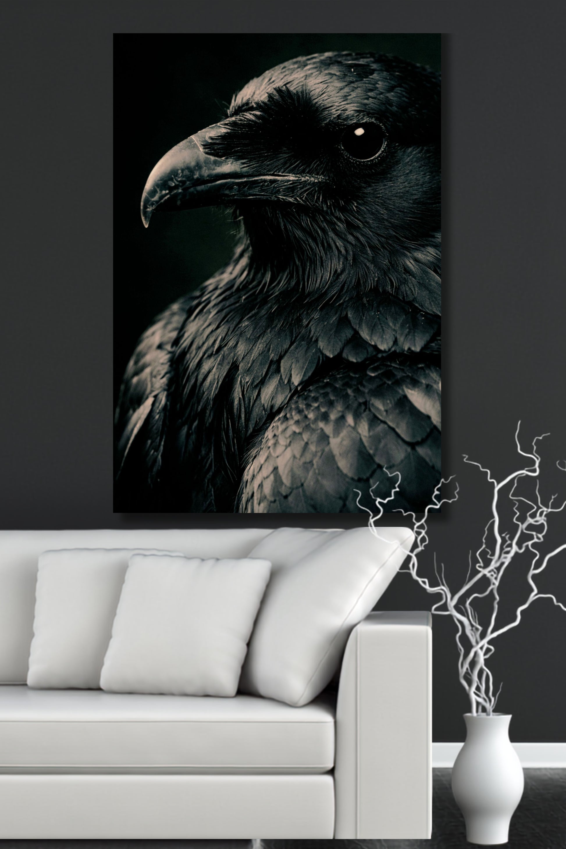 Poster eines schwarzen Raben an einer dunklen Wand über einem weißen Sofa in einem Wohnzimmer