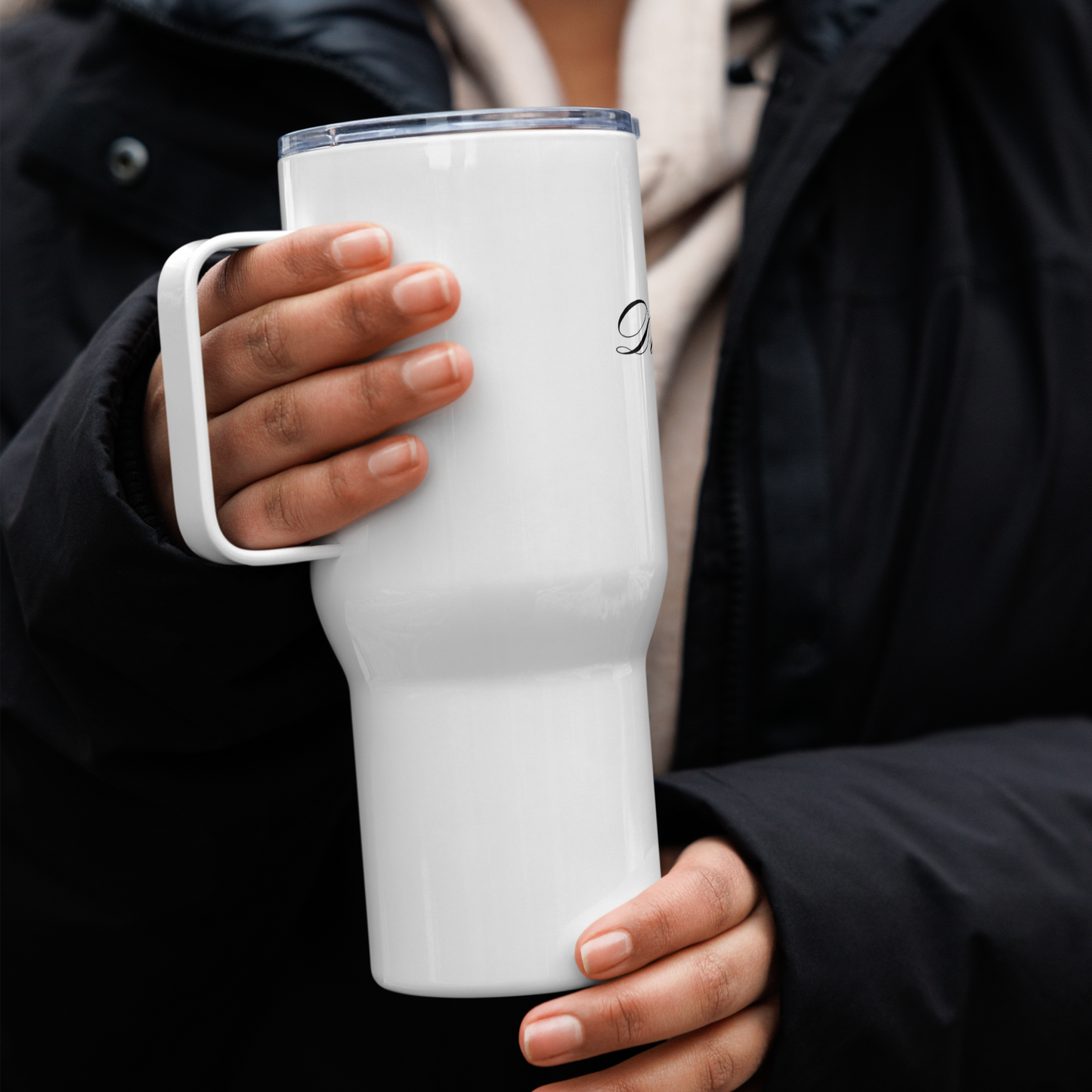 Reisebecher mit Griff „Dream Without Limits“ und goldenem Unendlichkeitssymbol in der Hand gehalten