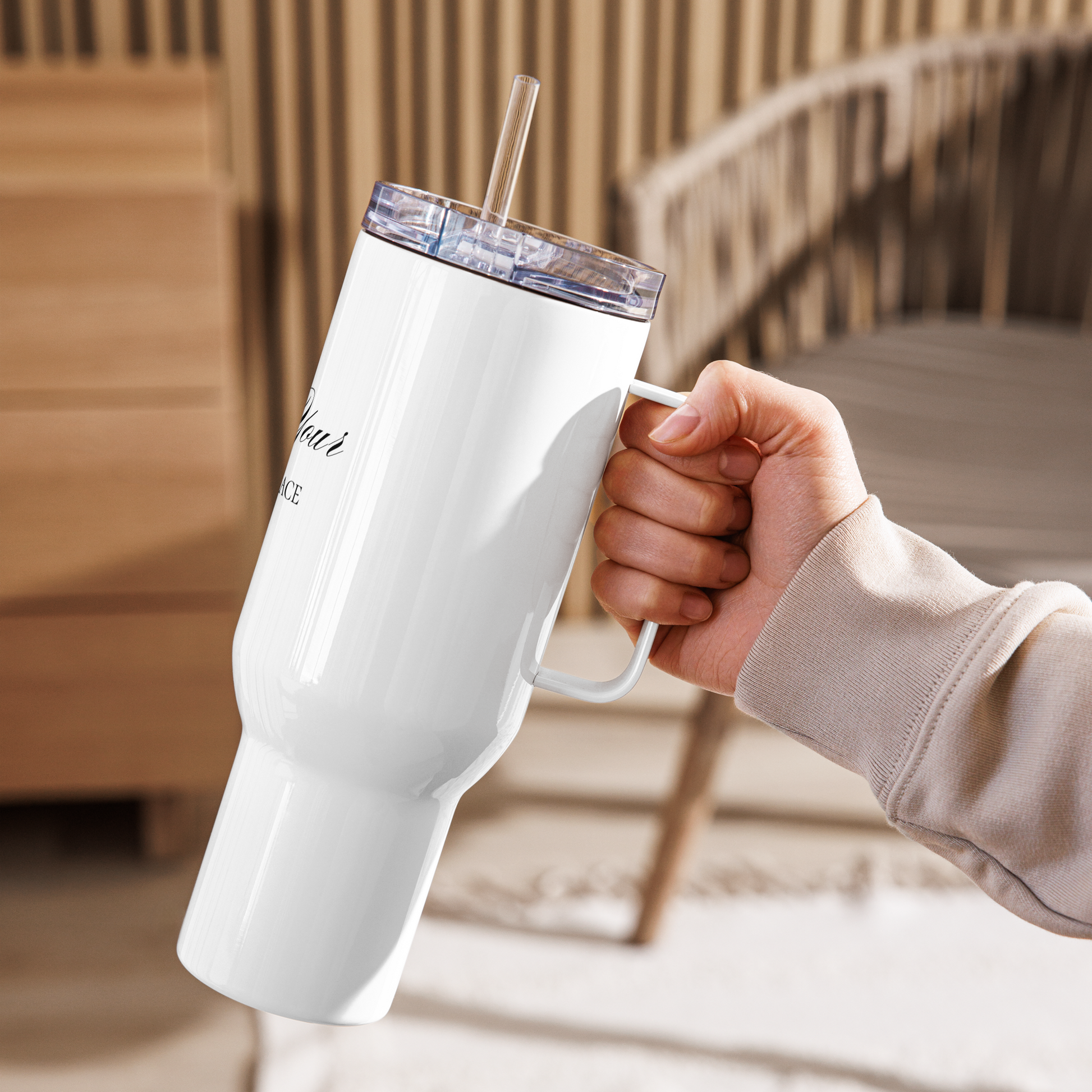 40-Unzen-Reisebecher mit Griff „Find Your Inner Peace“ und Strohhalm wird in der Hand gehalten und in einer hellen Wohnumgebung präsentiert