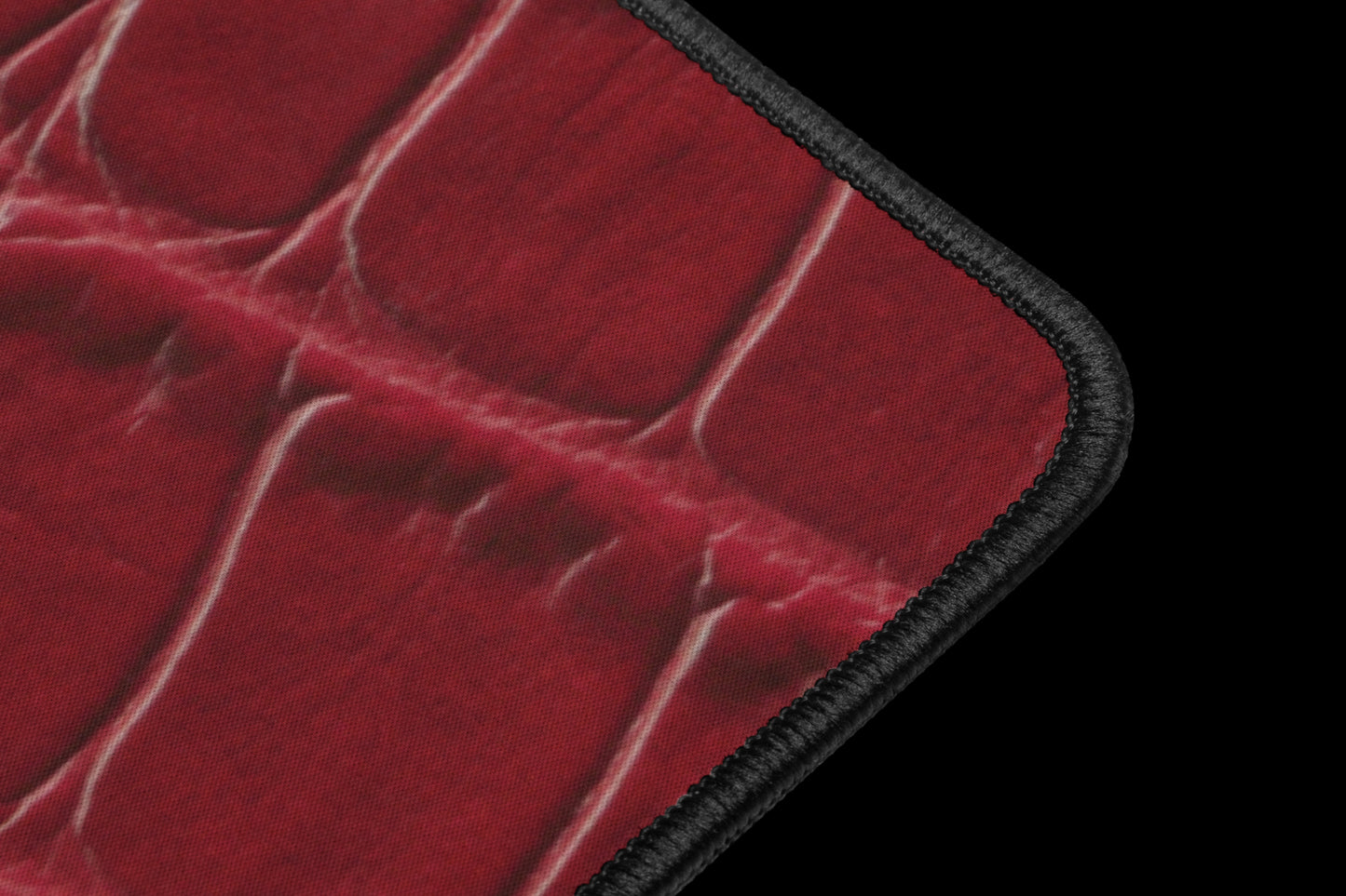 Detailaufnahme der schwarzen Kantenverarbeitung einer roten Desk Mat mit feiner Kroko-Struktur