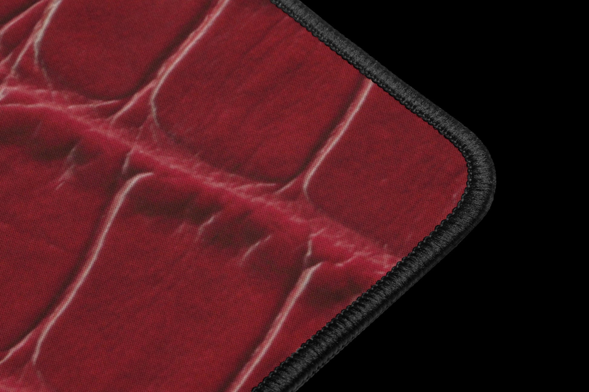 Detailaufnahme der schwarzen Kantenverarbeitung einer roten Desk Mat mit feiner Kroko-Struktur