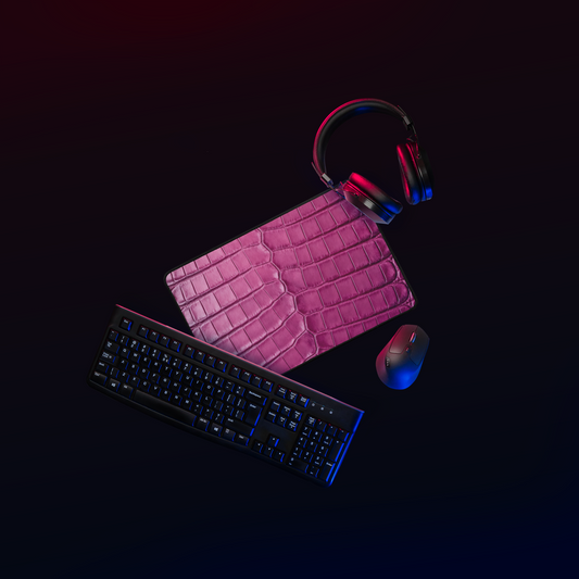 Magentafarbene Desk Mat in Krokoleder Optik mit Kopfhörern, Tastatur und Maus in dunklem Workspace mit moderner Beleuchtung.