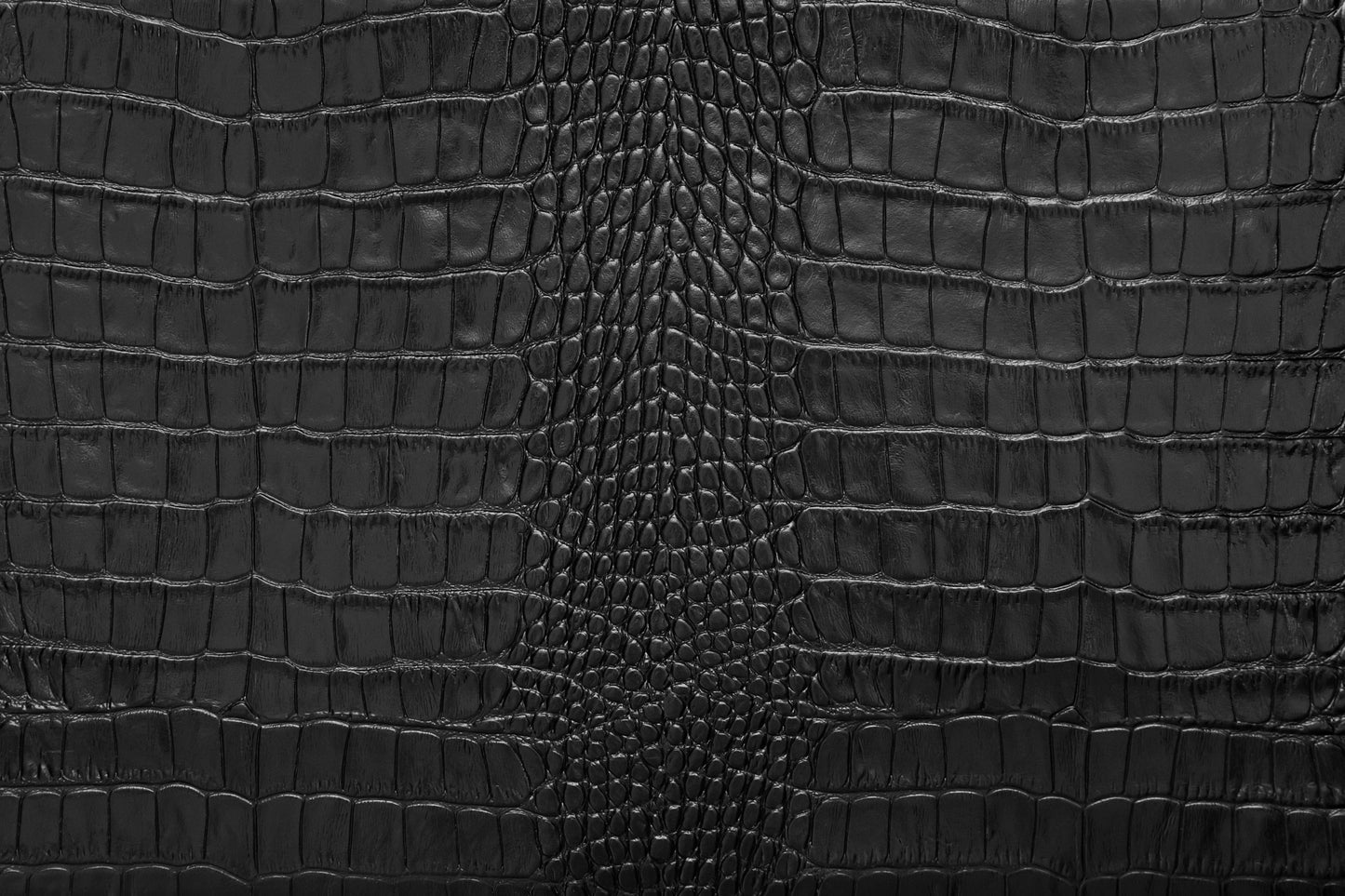 Vergrößerte Detailansicht der schwarzen Krokolederstruktur mit luxuriöser Tiefenwirkung und präzisen Lichtreflexen.