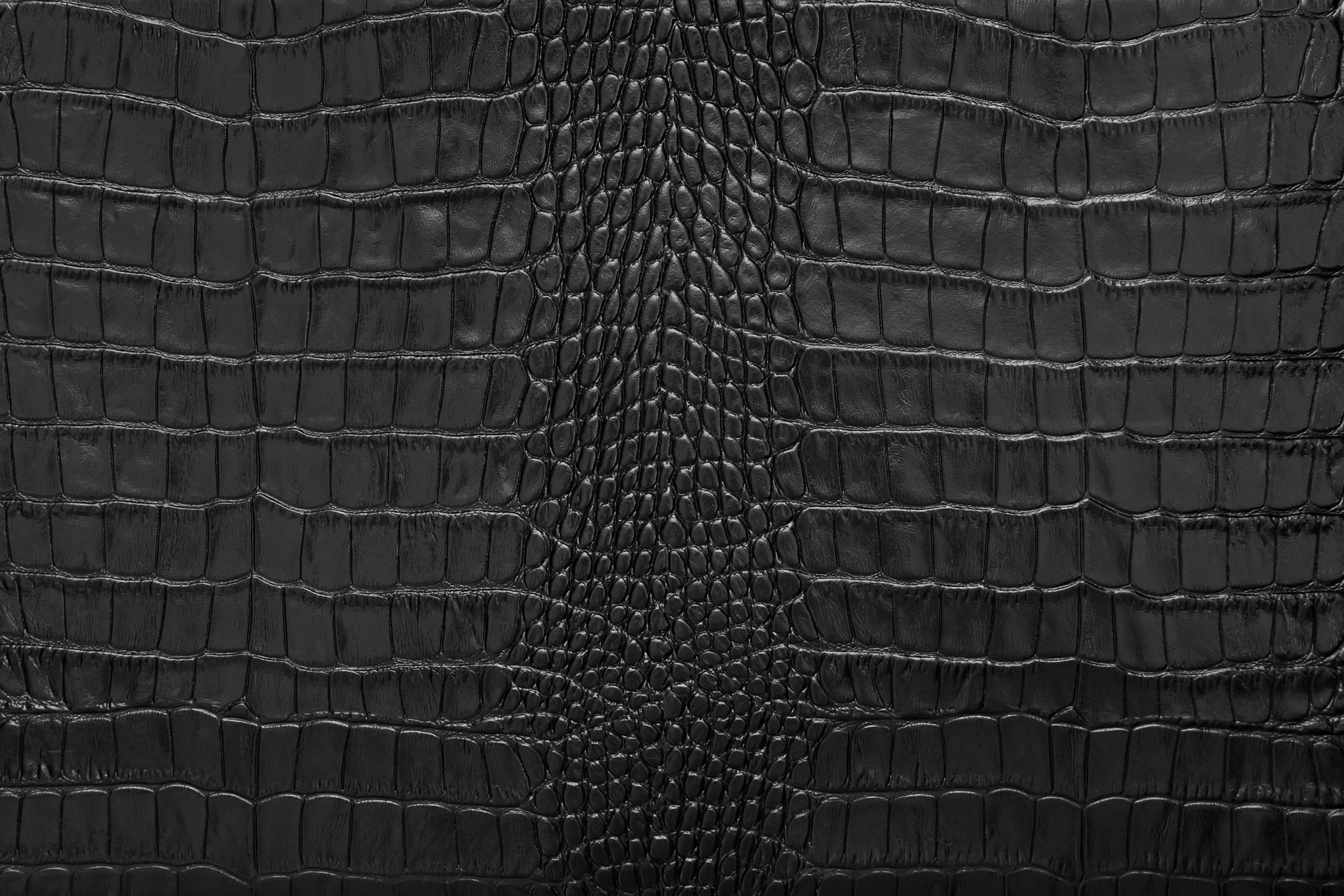 Vergrößerte Detailansicht der schwarzen Krokolederstruktur mit luxuriöser Tiefenwirkung und präzisen Lichtreflexen.