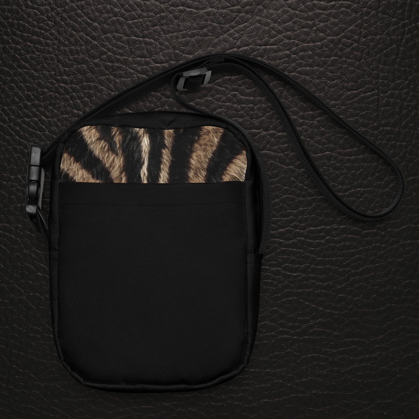 Zebra Muster Vorderseite der Crossbody Bag als Umhängetasche mit schwarzem Gewebe und natürlicher Fellstruktur als Hauptansicht auf dunklem Leder Hintergrund