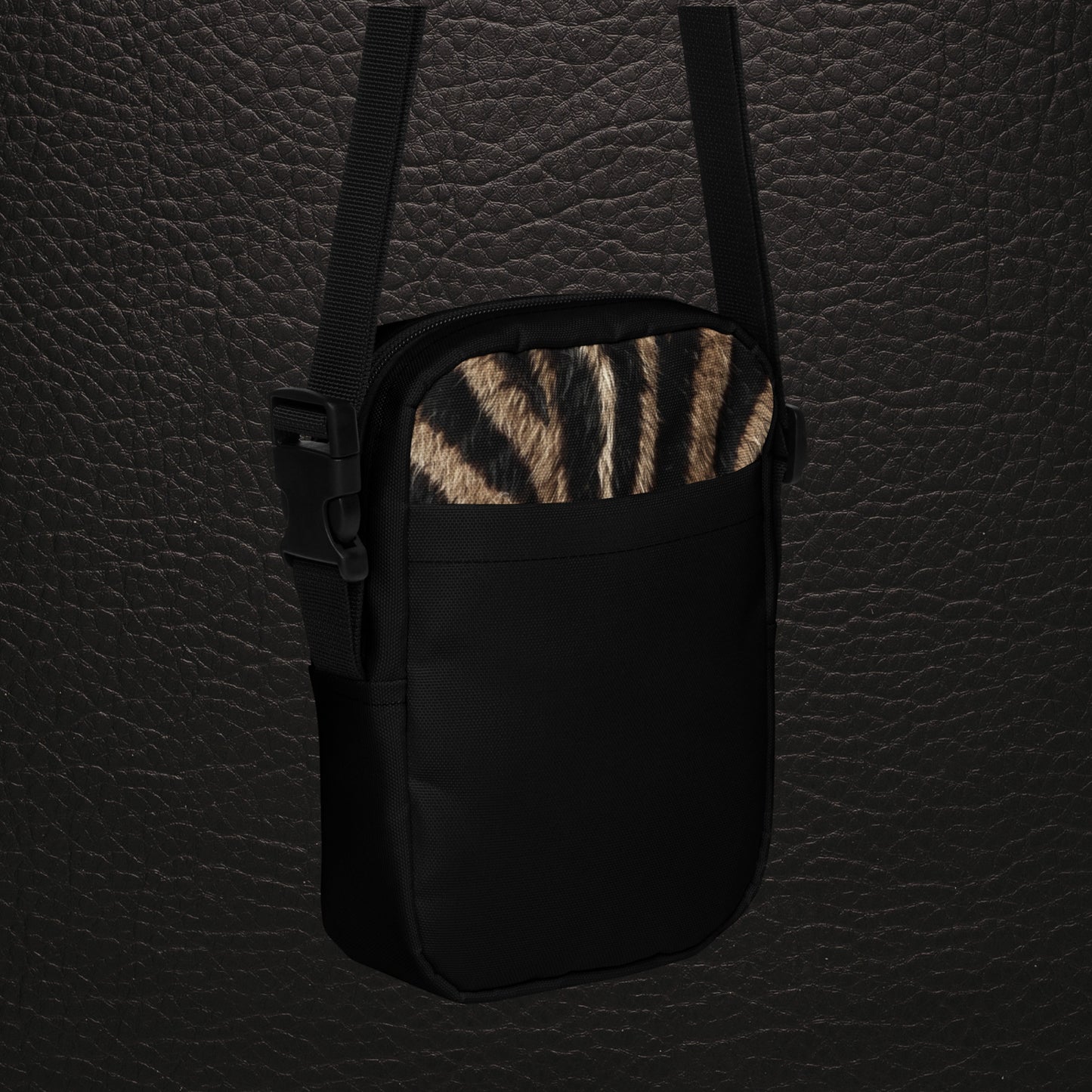 Schrägansicht der Vorderseite der kompakten Zebra Muster Tasche mit natürlichem Fellprint, schwarzer Außentasche und schwarzem Trageriemen