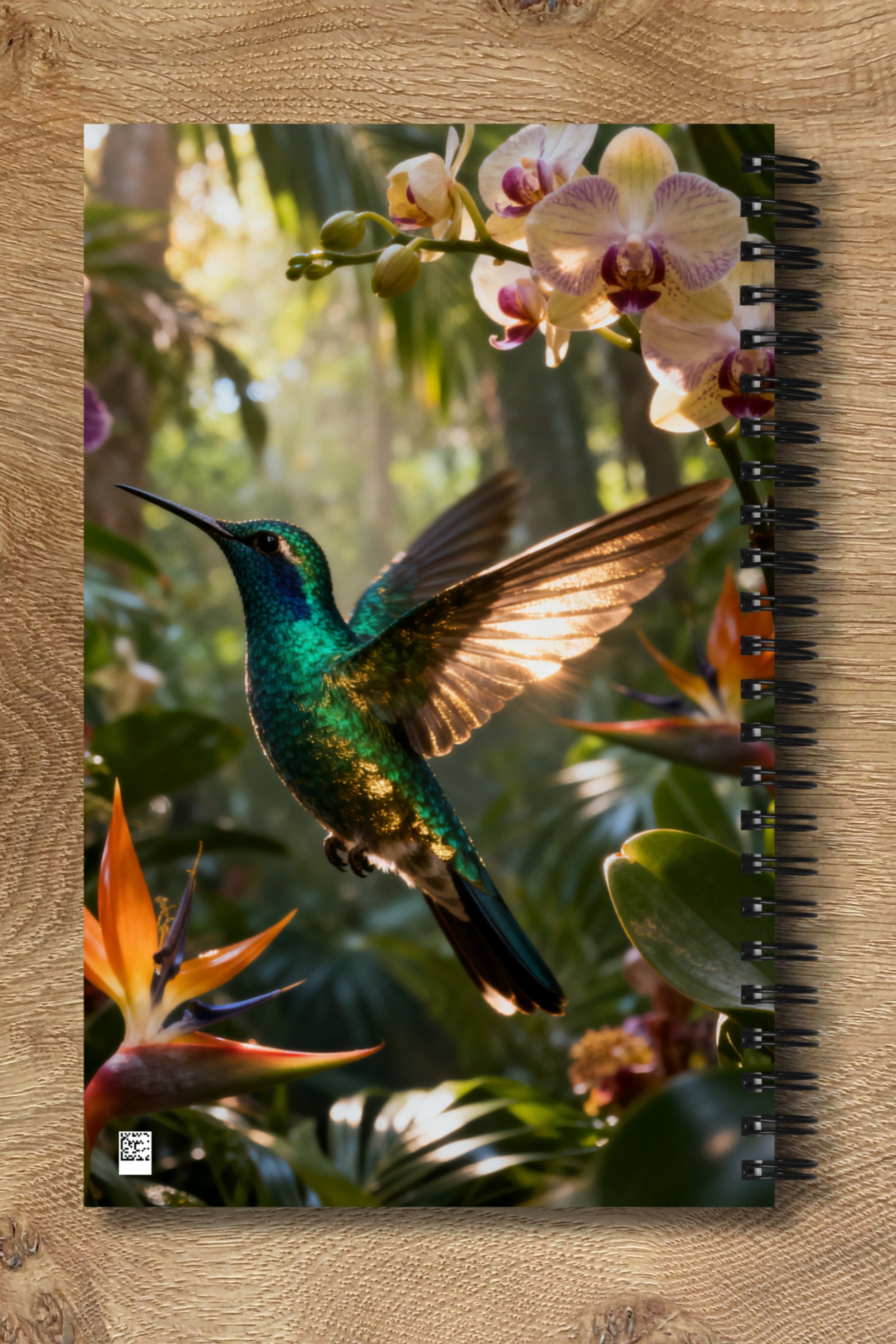 Spiralnotizbuch mit schillerndem Kolibri vor tropischer Regenwaldkulisse als Rückseitenansicht mit harmonisch fortgeführtem gespiegeltem Motiv.