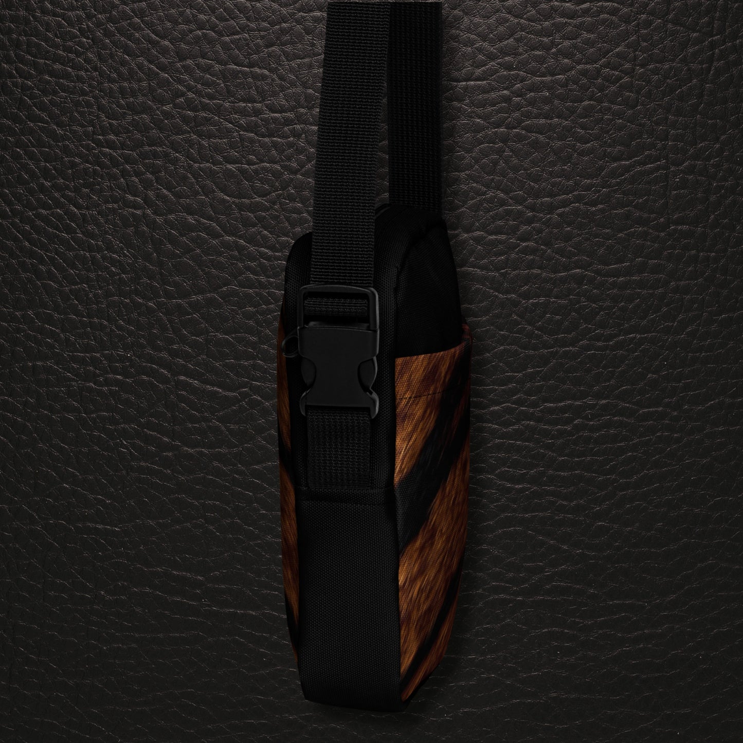 Seitenansicht der Tigerfell Crossbody Bag mit kompakter Silhouette, dunklem Schultergurt und Verschluss