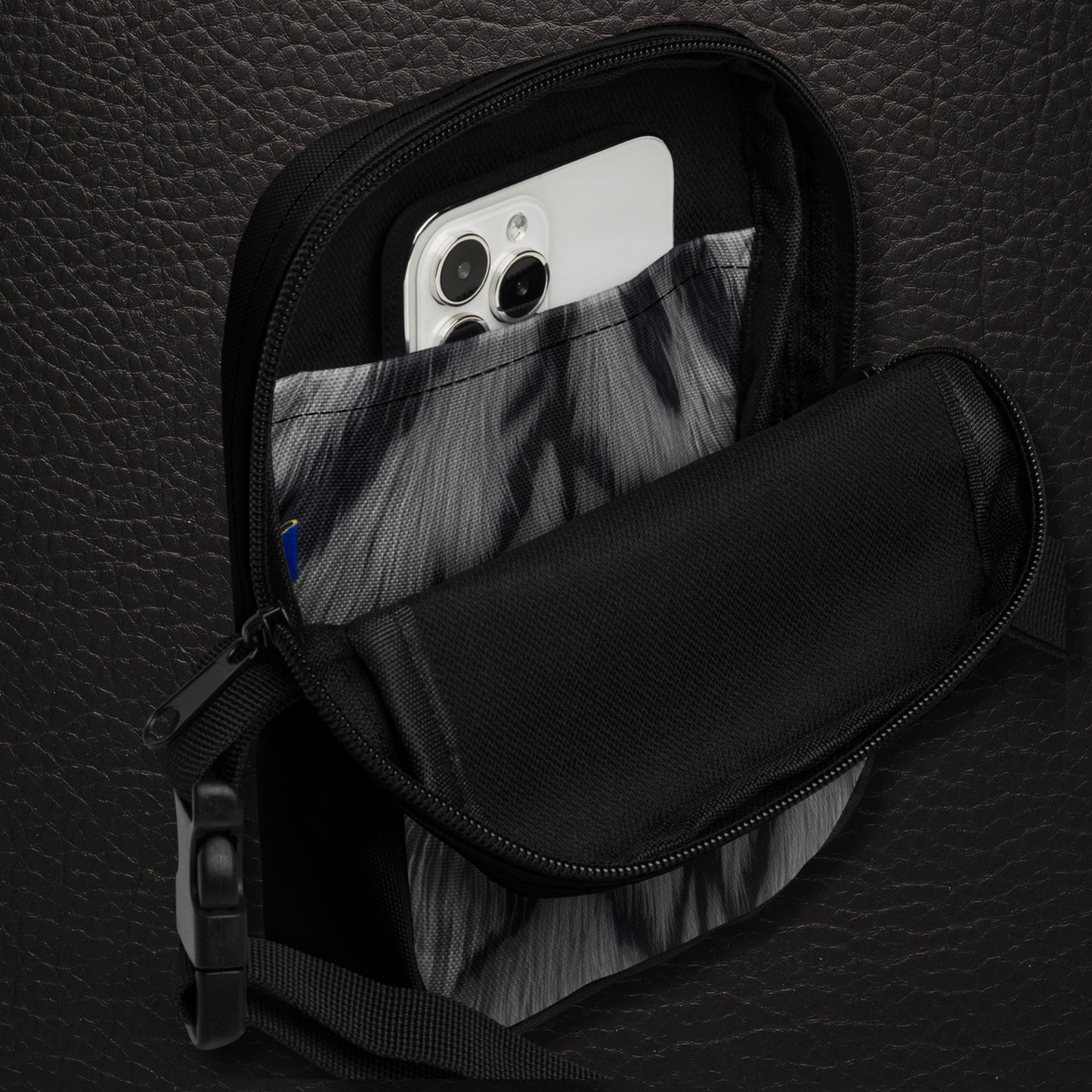 Geöffnete Crossbody Bag mit Innenfach und schwarzem Innenbereich und bedruckter Innentasche