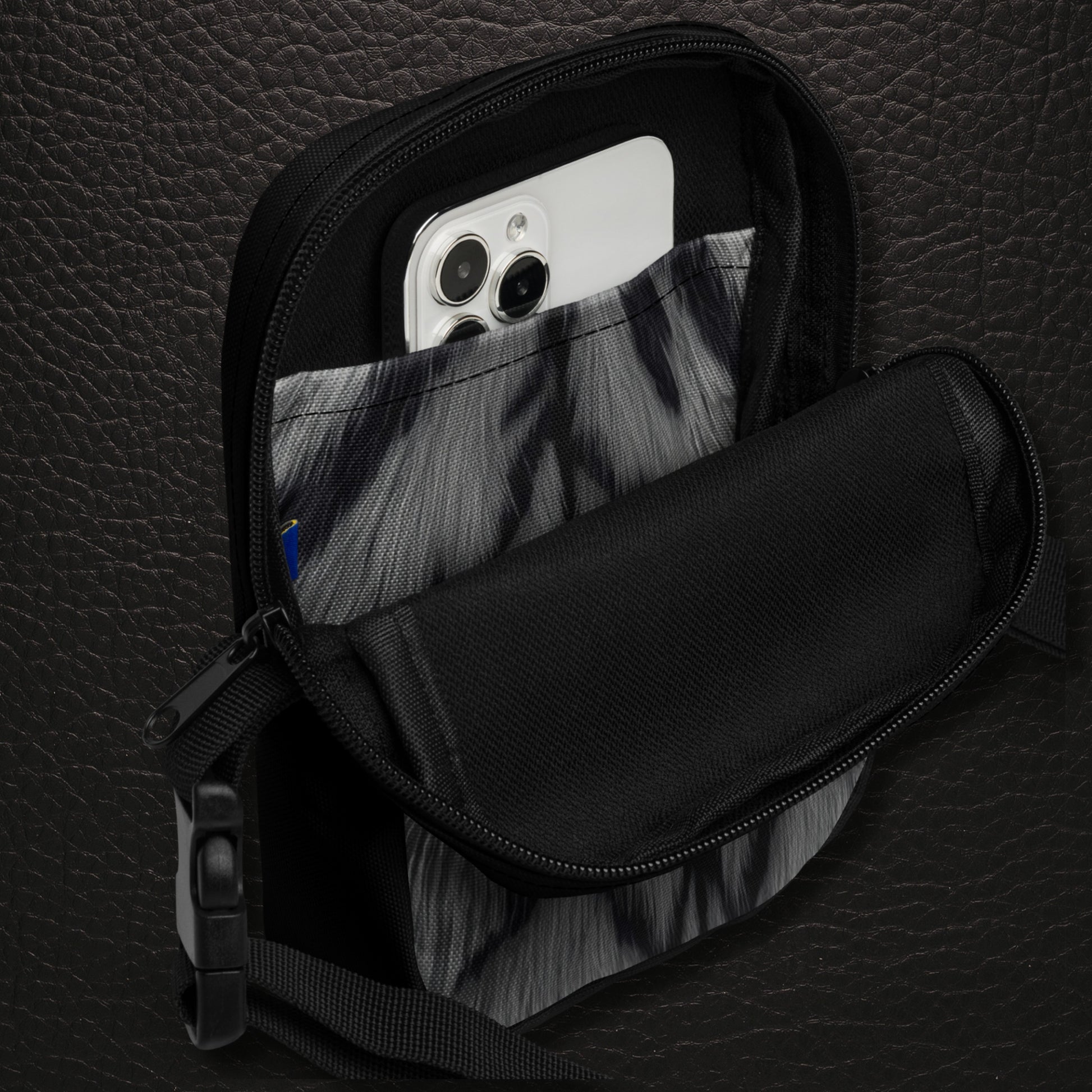 Geöffnete Crossbody Bag mit Innenfach und schwarzem Innenbereich und bedruckter Innentasche